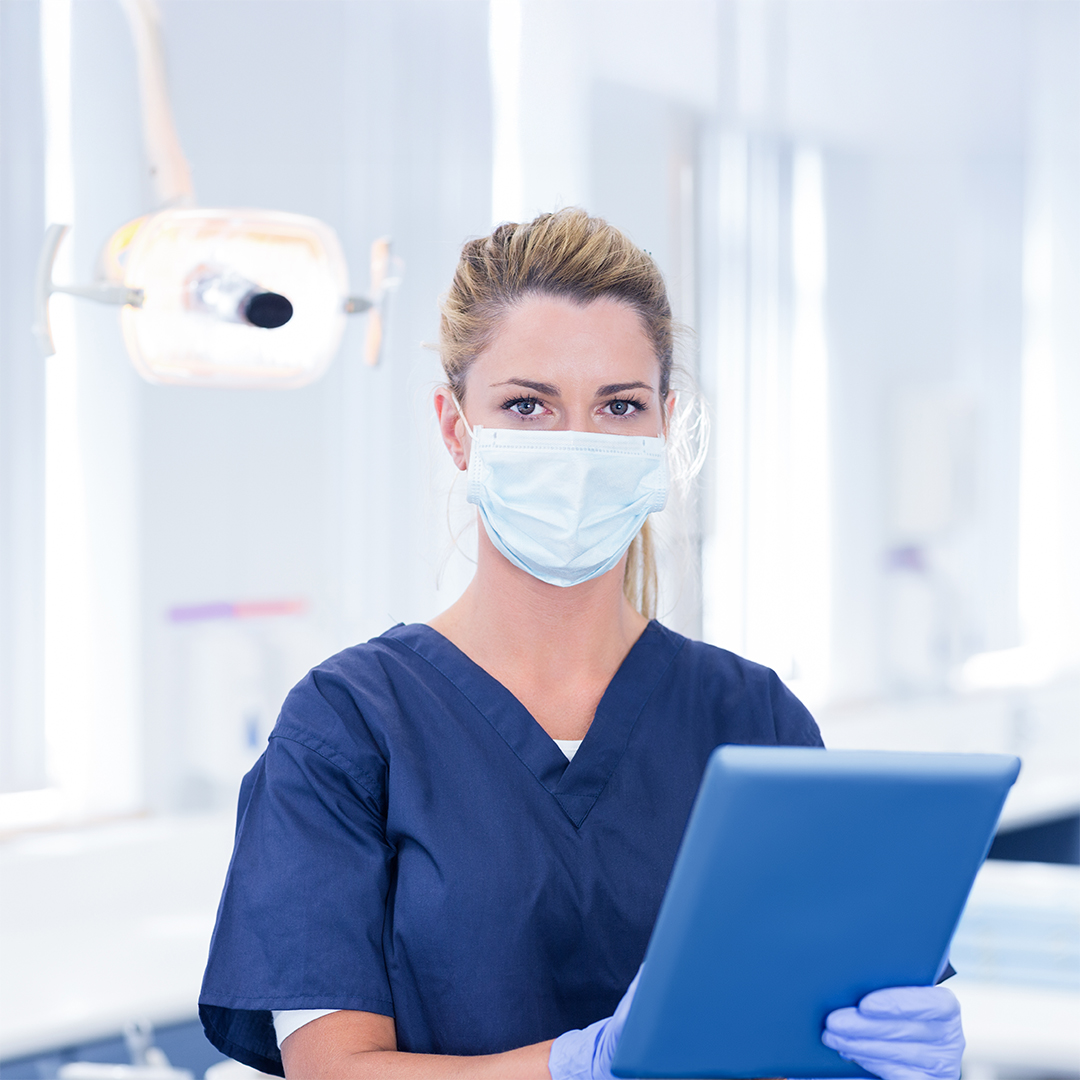 FAS ANDI Salute - immagine Piani Sanitari Dentista con in mano un tablet all'interno di uno studio dentistico
